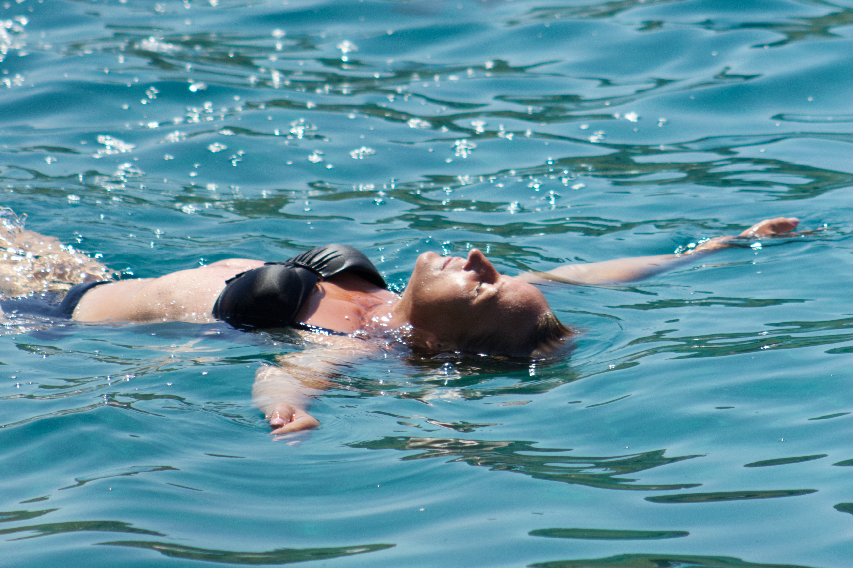 Woman floating peacefully in crystal-clear Adriatic Sea during a Kornati boat excursion from Pakoštane, Croatia