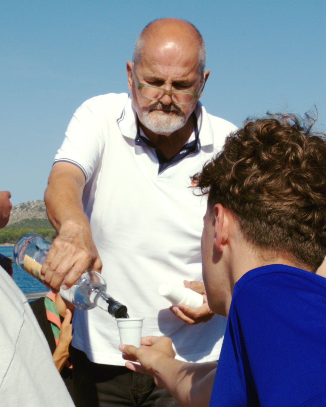 Crew member serving drinks to guests onboard during the Kornati boat trip.
