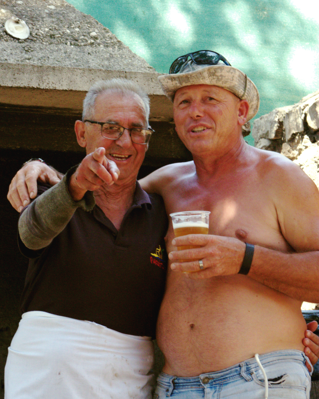 Two crew members enjoying cold drinks and smiling during the Flipper One boat excursion.