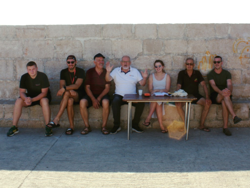 Flipper One crew sitting together by the sea in Pakoštane, Croatia — 8-member team ready to guide guests on unforgettable Kornati and Telašćica boat trips.