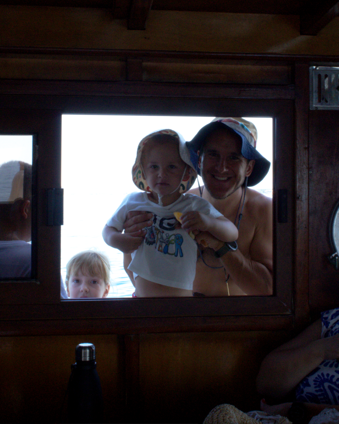 Warm family moment captured through cabin window during a relaxing Croatian boat tour.