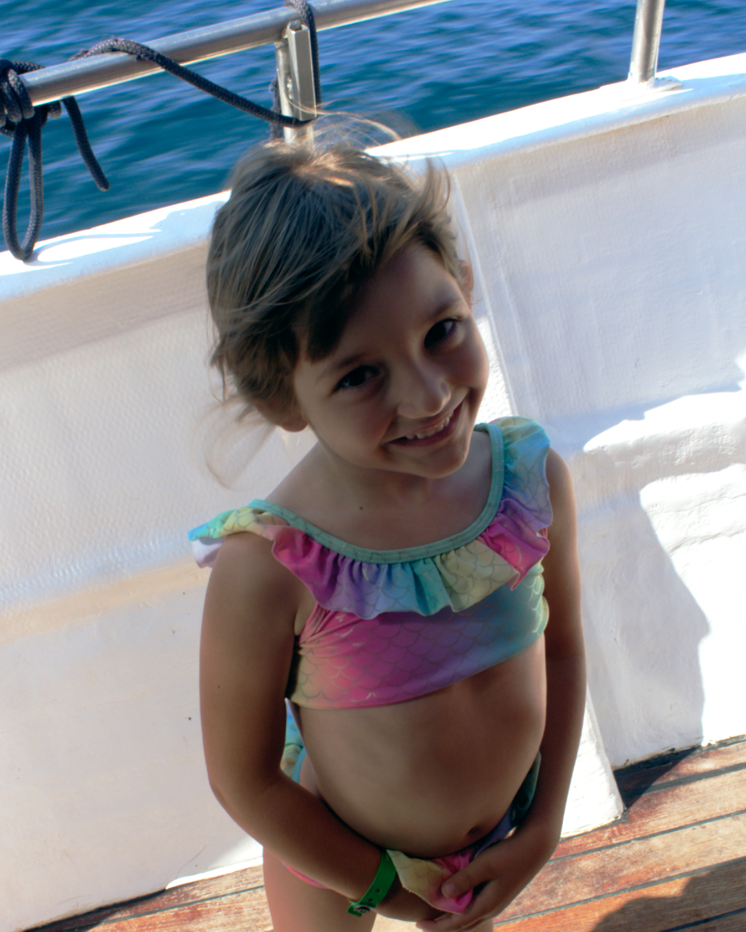 Young girl in colorful swimsuit smiling happily during a summer boat trip with Flipper One Croatia.