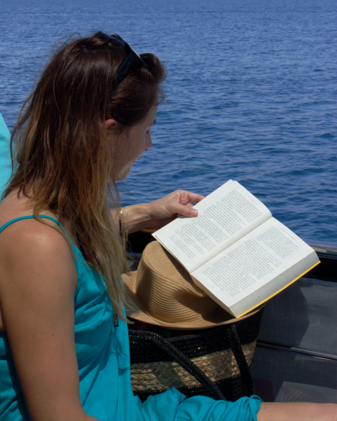 Relaxing solo moment with a good book and sea views during a peaceful boat journey in Dalmatia.