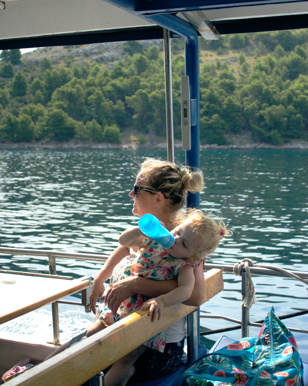 Woman holding a baby while looking out over the sea on a Flipper One boat excursion.